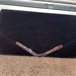 Black clutch hand bag, brand unknown.